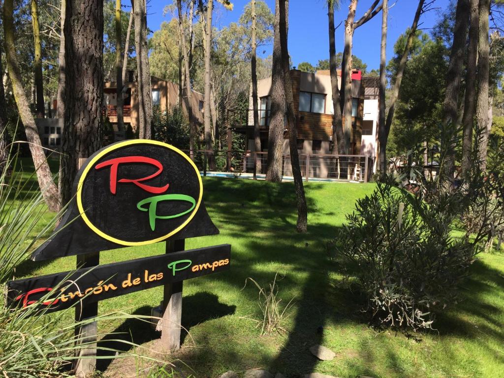 una señal para un parque con una casa al fondo en Rincón de las Pampas en Mar de las Pampas