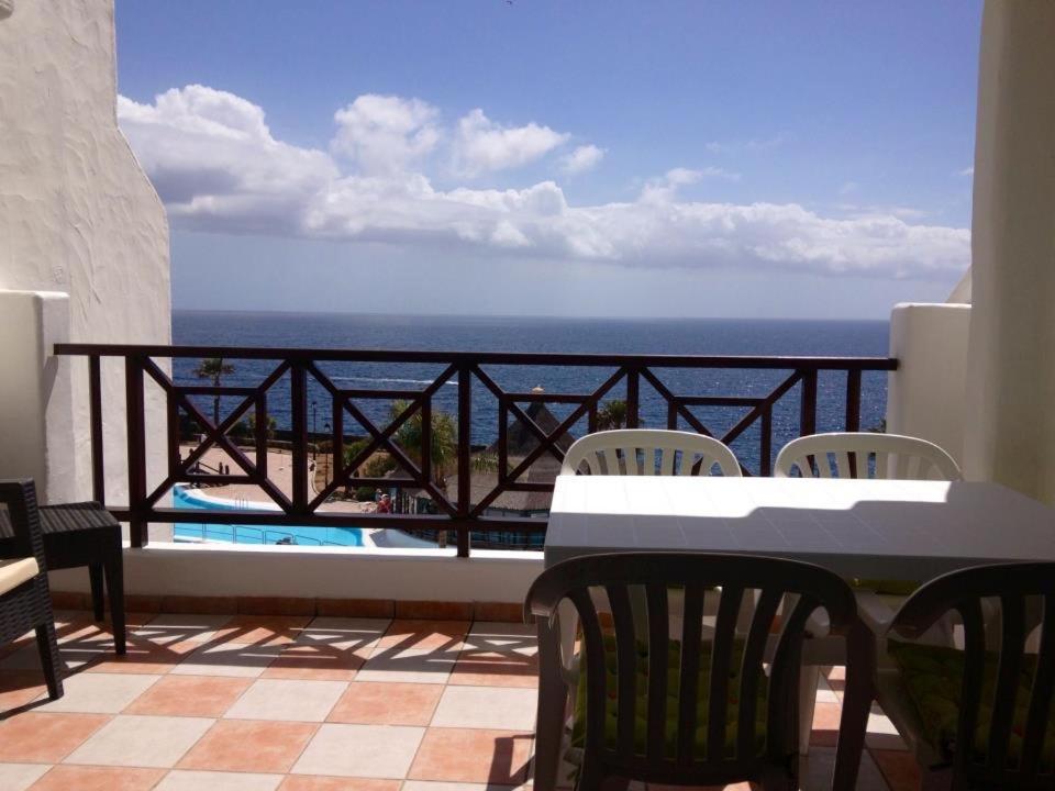 balcón con mesa, sillas y vistas al océano en Rocas Del Mar en Costa Del Silencio