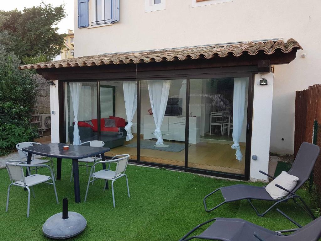 a patio with a table and chairs on the grass at les orangers in Cannes
