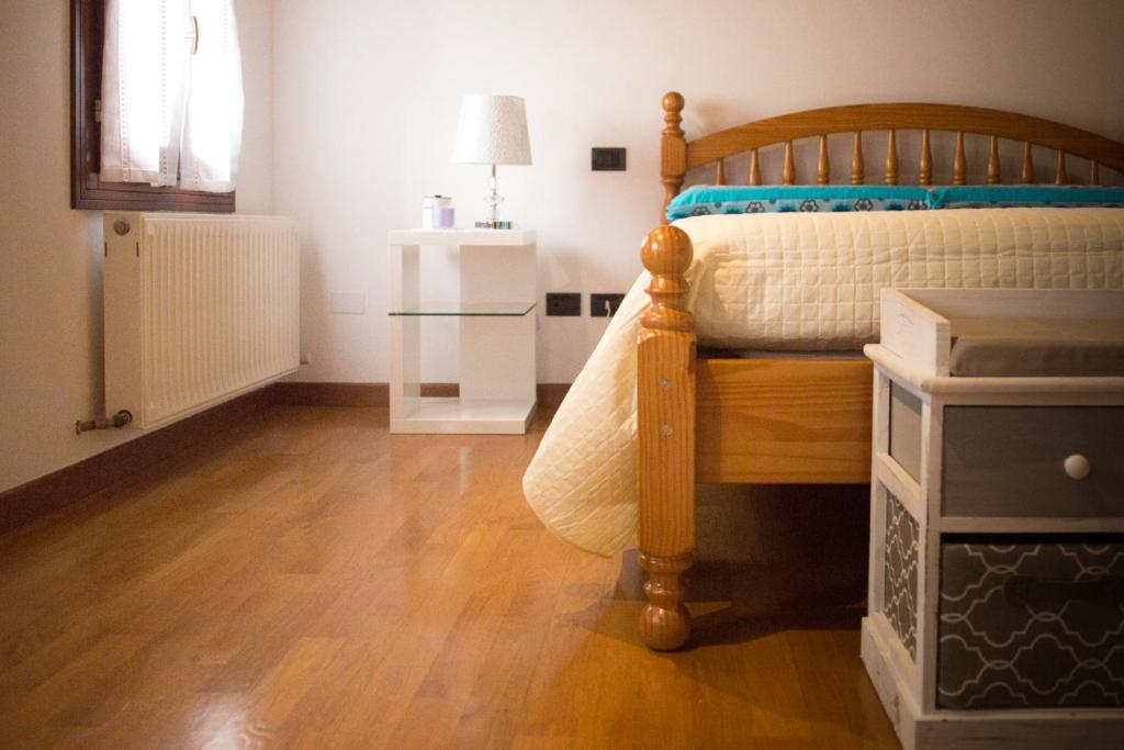 1 dormitorio con 1 cama y suelo de madera en Ca' Natalìa, en Valdobbiadene