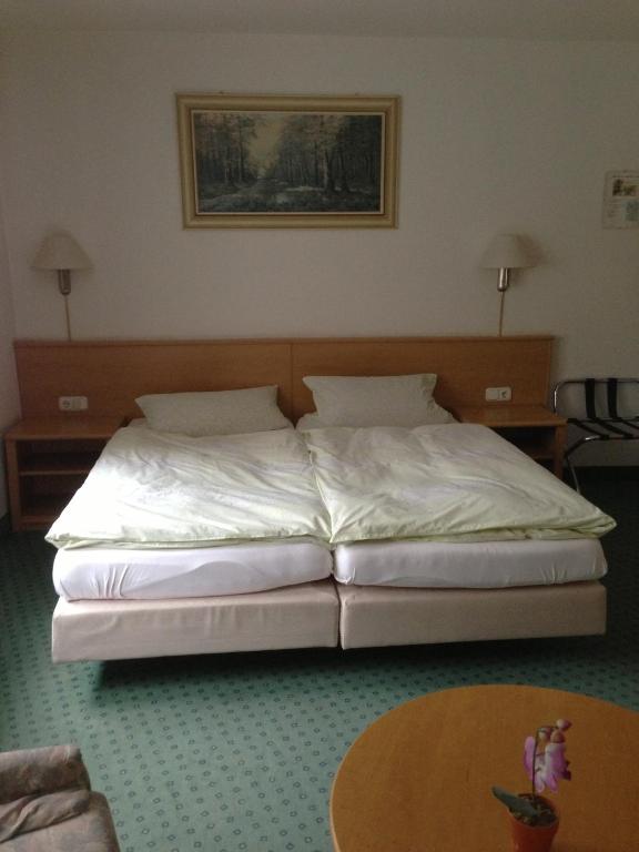 a large bed in a room with a table at Pension Freund in Rothenburg ob der Tauber