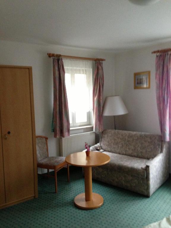 a living room with a couch and a table at Pension Freund in Rothenburg ob der Tauber