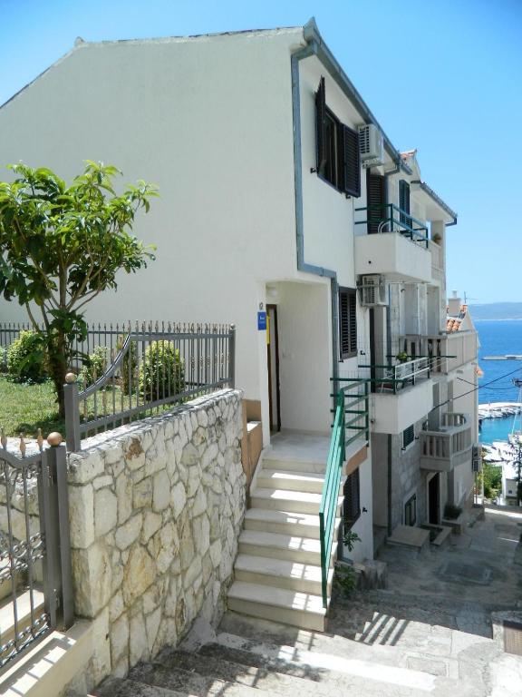 a white building with stairs and a wall at Ema in Brela