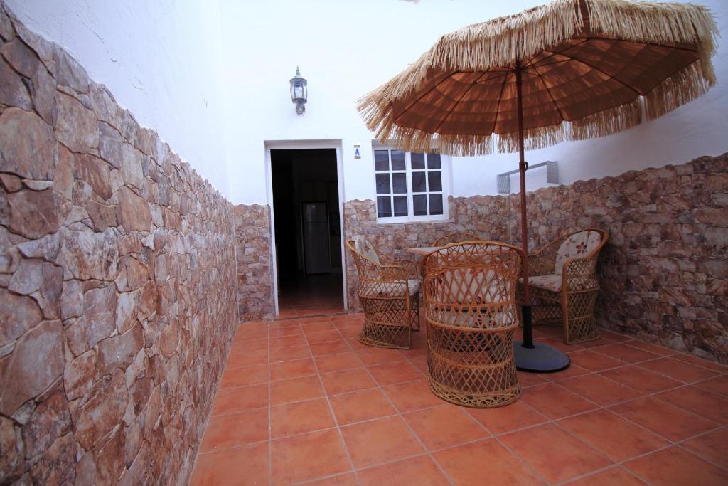 un patio con tavolo, ombrellone e sedie di MONTAÑA VALLES DE ORTEGA - A a Valles de Ortega