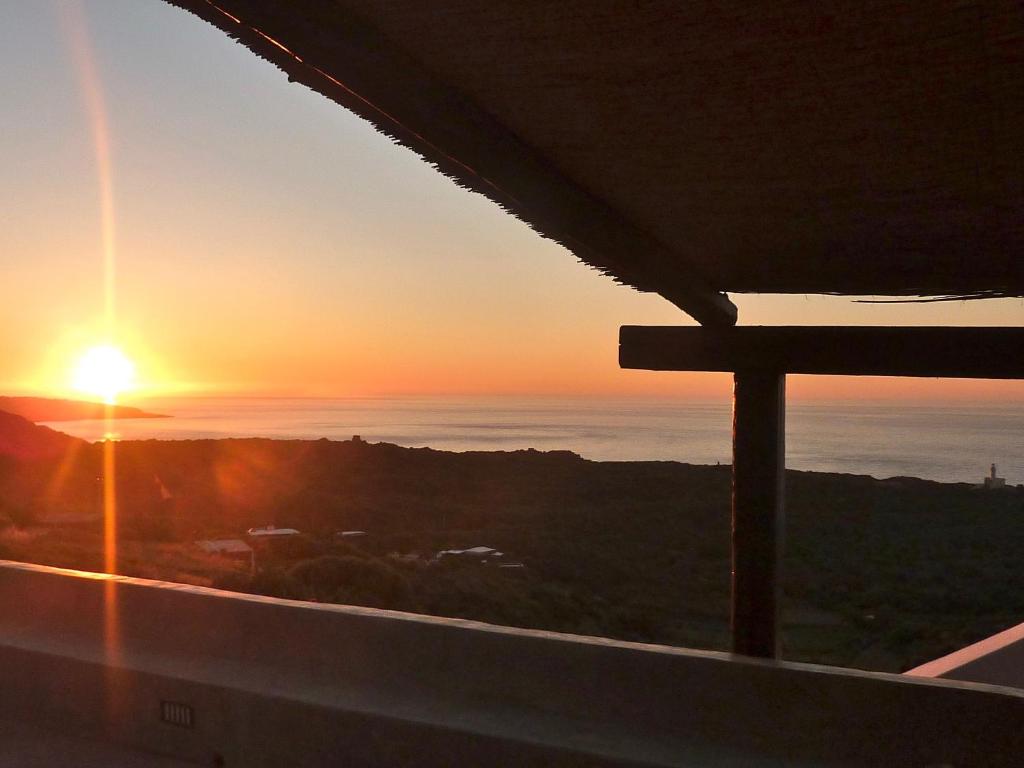 einen Sonnenuntergang vom Balkon eines Gebäudes in der Unterkunft Dammuso "La Catalana" in Pantelleria