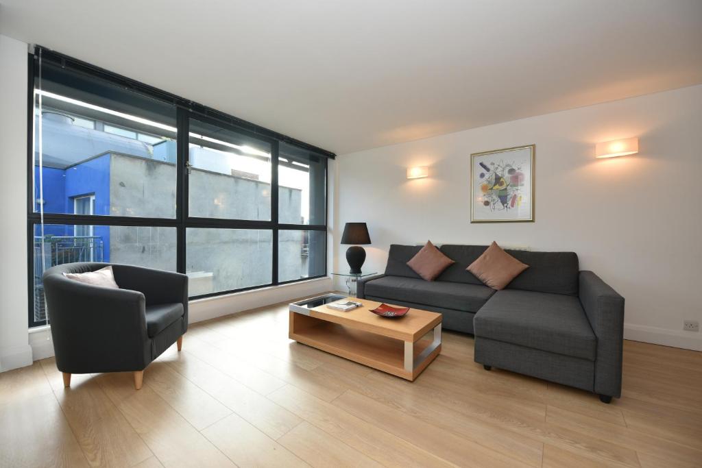 a living room with a couch and a table at Modern & Peaceful Flat 2 Mins to Tube in London
