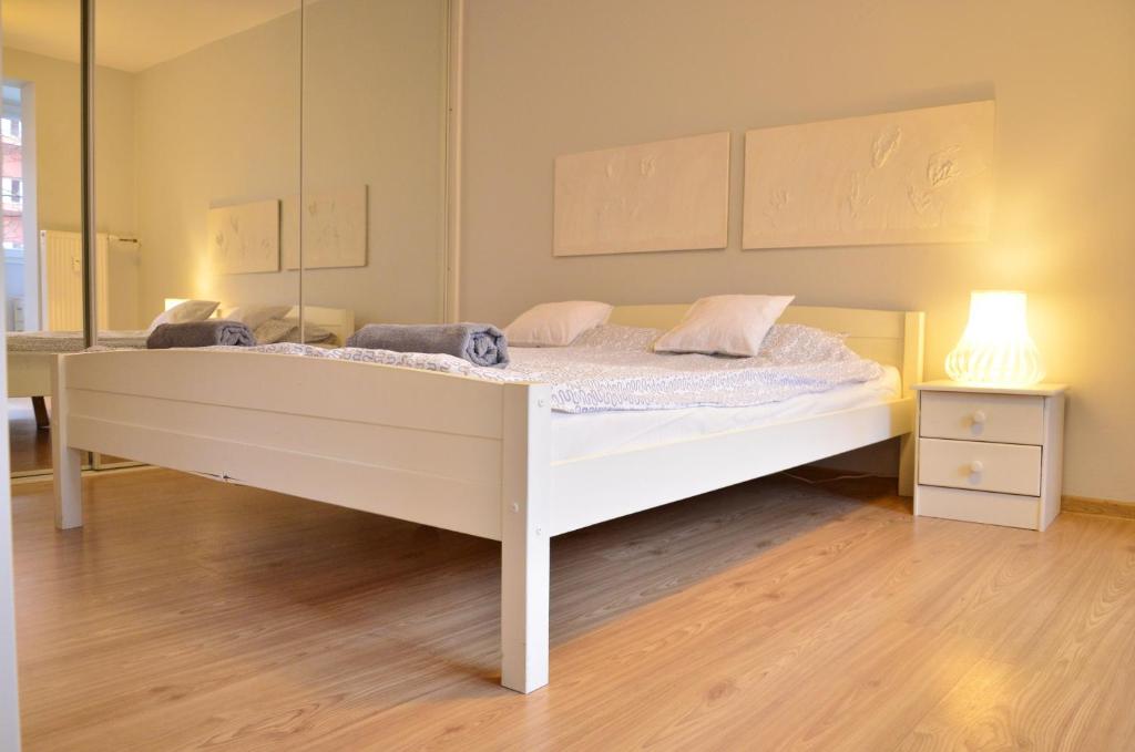 een wit bed in een kamer met een spiegel bij Cozy apartment by the Old Town in Gdańsk