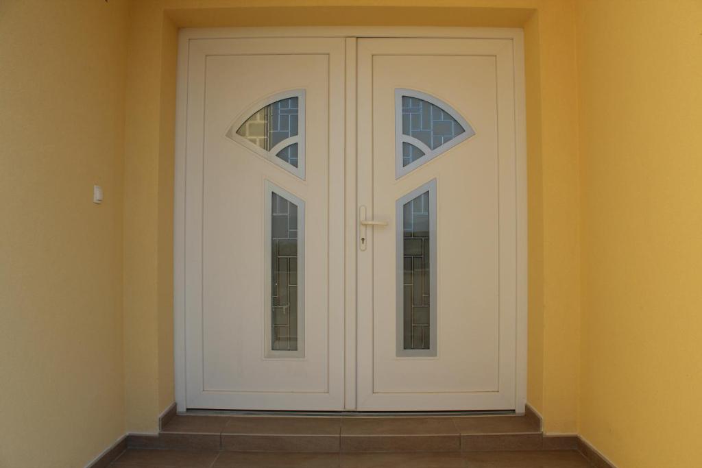 a white door with two windows in a room at Apartmani Marin in Vrbnik
