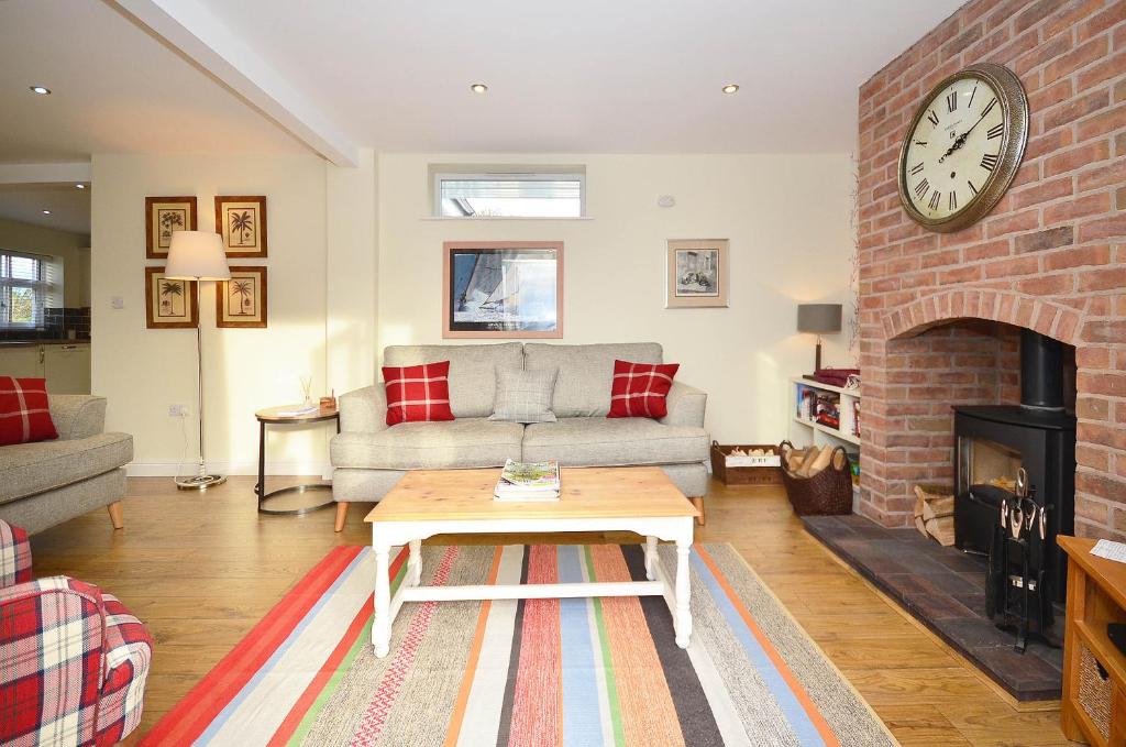 a living room with a couch and a brick fireplace at The Stables at Flash Farm House in Crewe