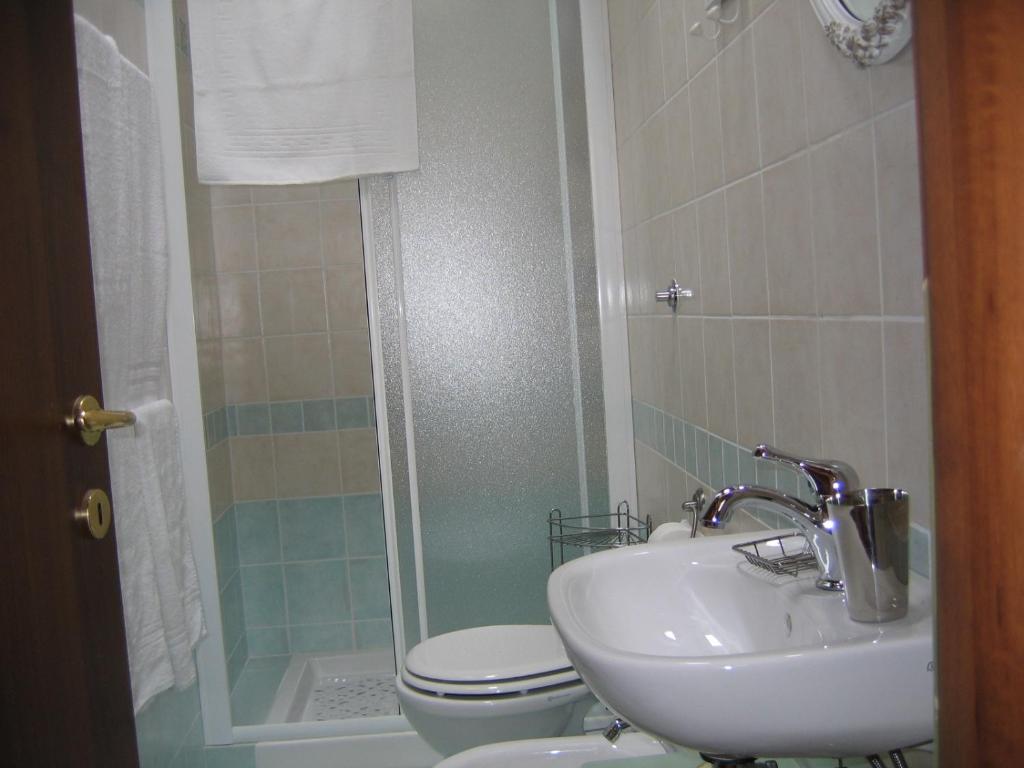 a bathroom with a sink and a toilet and a shower at La Papaya in Marina di Pisa