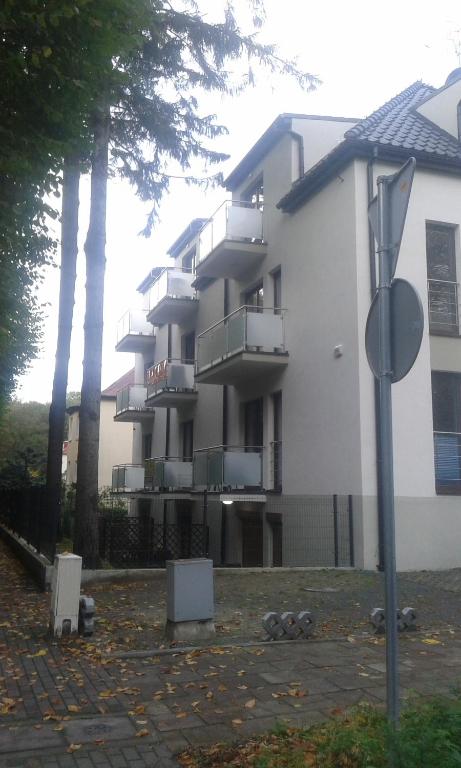 a large white building with trees in front of it at Apartament JULIA in Świnoujście