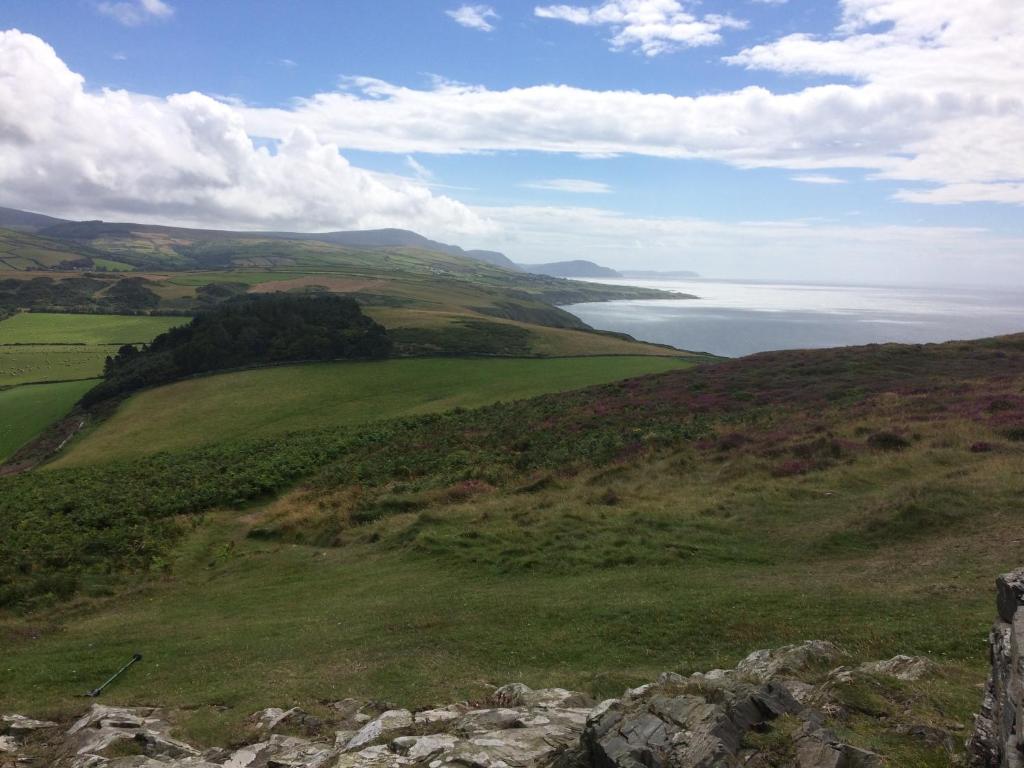 a green hillside with a view of a body of water at Knockaloe Beg Farm in Patrick