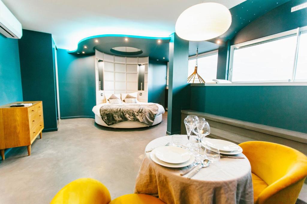 een kamer met een bed en een tafel en stoelen bij Parenthèse Concept Room in Toulouse