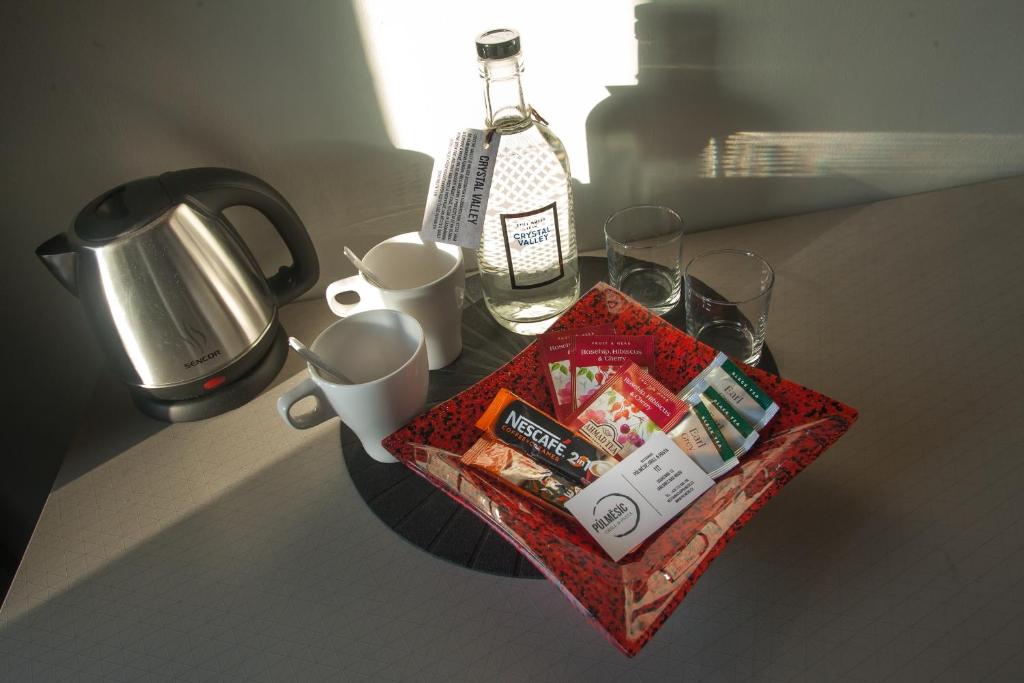 Una bandeja de bocadillos y tazas en un mostrador. en Pension Půlměsíc, en Jablonec nad Nisou