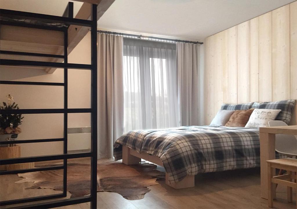 een slaapkamer met een bed en een groot raam bij Apartmány na sjezdovce Dolní Morava in Dolní Morava