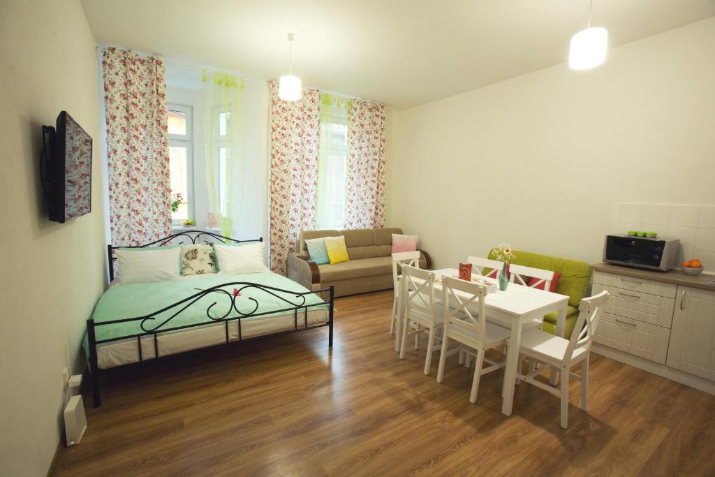テプリツェにあるBest apartments Tepliceのベッド、テーブル、椅子が備わる小さな客室です。