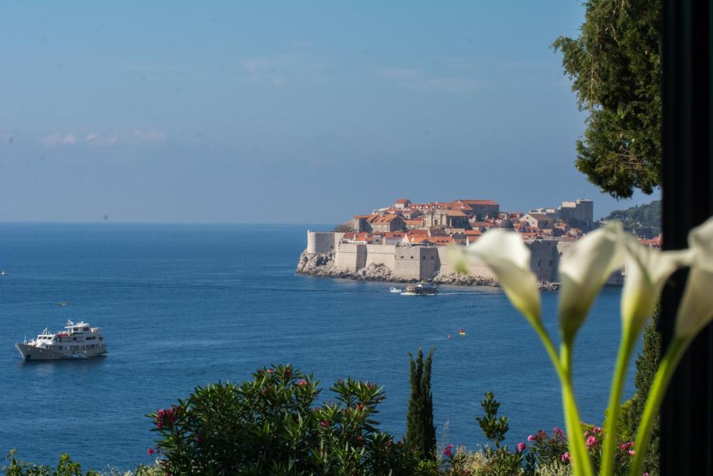 Room St. Jacob Dubrovnik في دوبروفنيك: قارب في الماء مع مدينة على الشاطئ