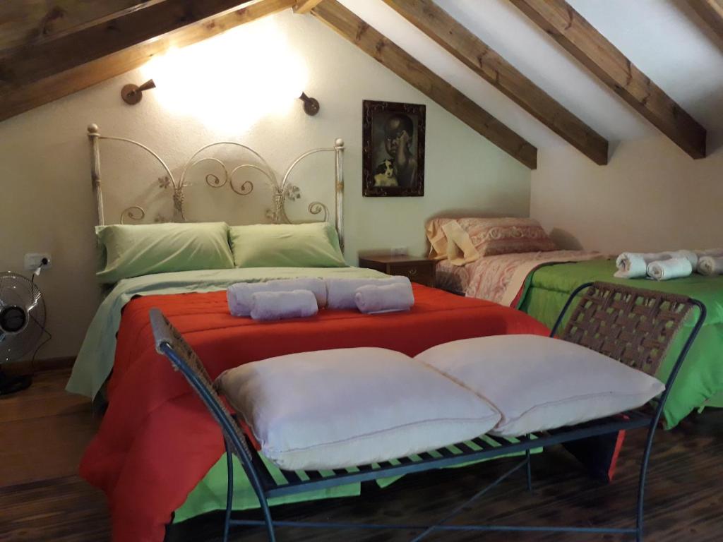 a bedroom with two beds with red and green sheets at Quinta Santana in José de la Quintana