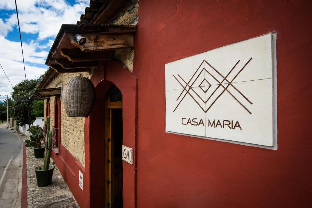 a sign on the side of a red building at Casa María Guest House in Santa Cruz Etla