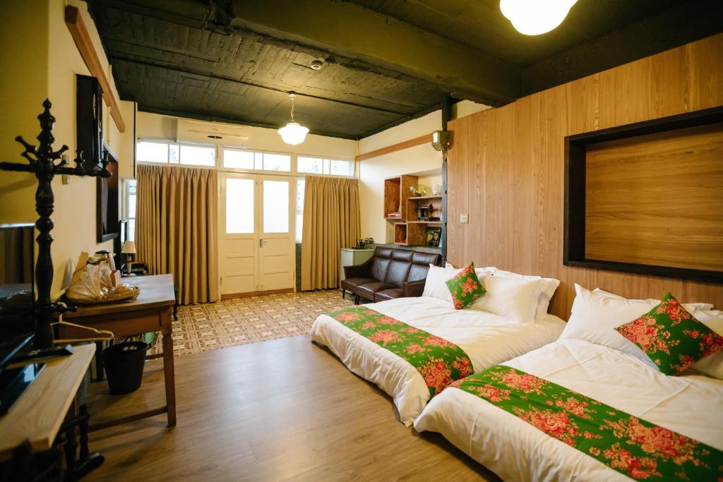 a living room with two beds and a couch at 84 In Tainan in Tainan