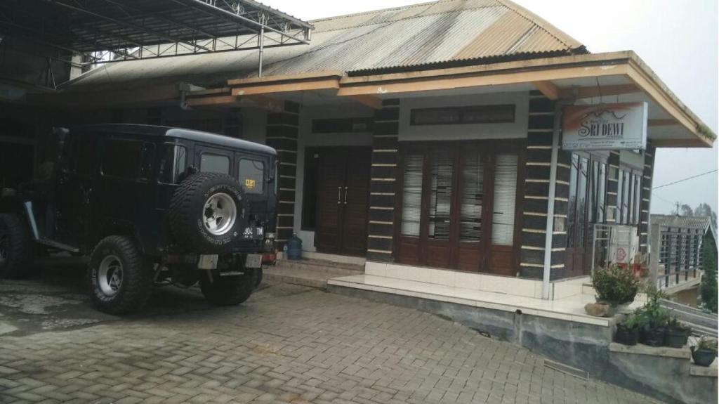 ein schwarzer Jeep, der vor einem Gebäude parkt in der Unterkunft Sri Dewi Homestay in Ranuyoso