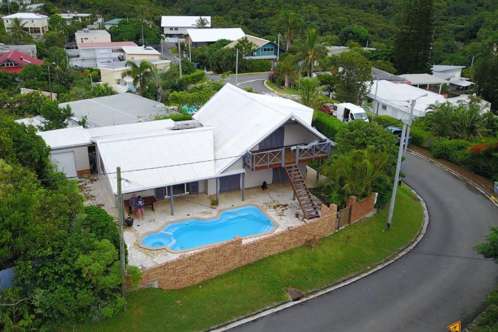 Cette chambre offre une vue sur une maison dotée d'une piscine. dans l'établissement Bas de villa Noumea, à Nouméa