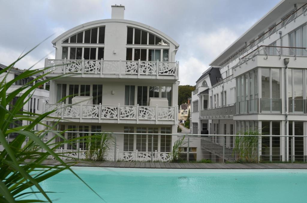 a building with a swimming pool in front of it at Villa "Johanna" Sellin - WG12 mit Kamin und zwei Balkonen in Ostseebad Sellin