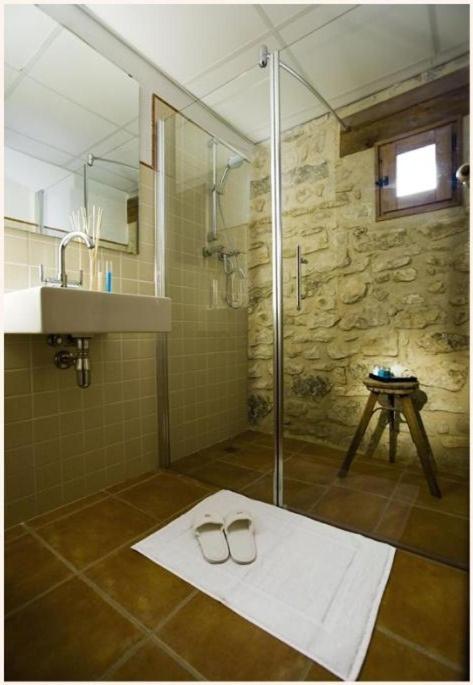 baño con ducha y 2 vasos en el suelo en Apartamentos Doña Candida, en Valderrobres