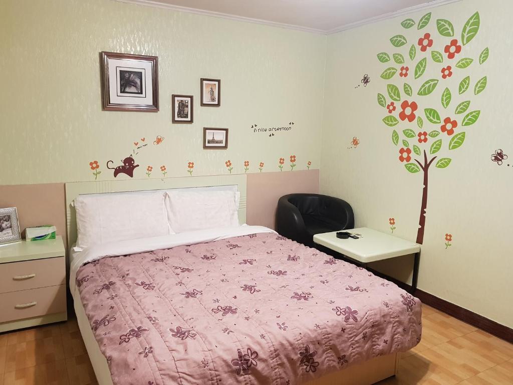 桃園區的住宿－三和旅宿，一间卧室配有一张带粉色毯子的床