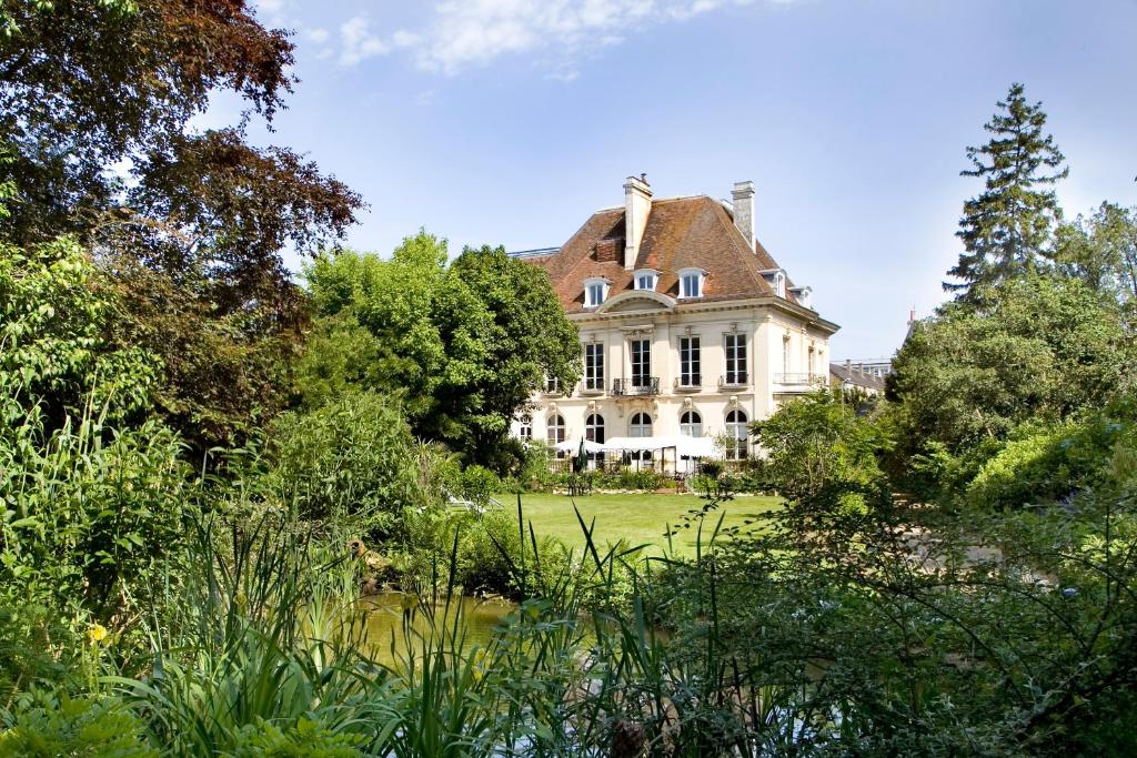 een oud huis midden in een tuin bij La Gourmandine in Châtellerault