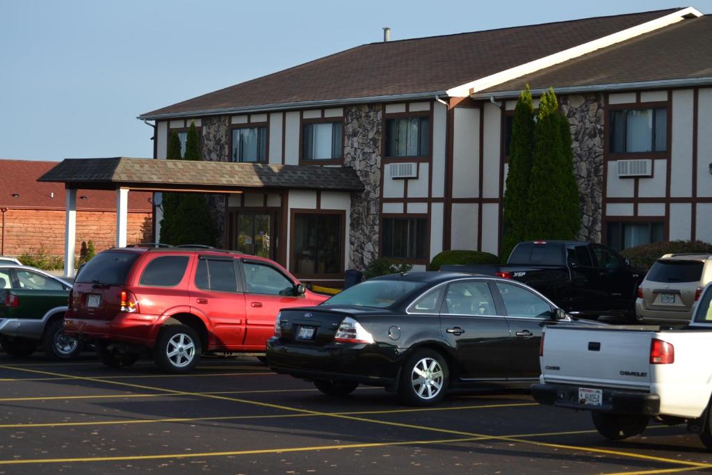 a parking lot with cars parked in front of a building at Sky Lodge Inn & Suites - Delavan in Delavan