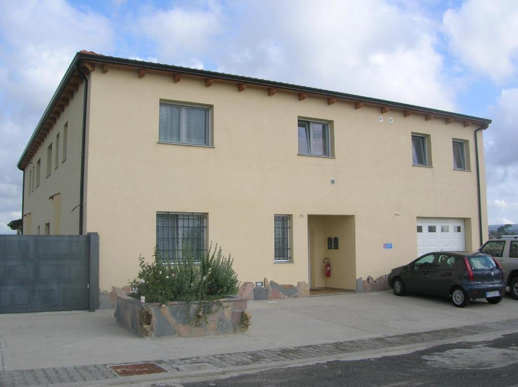 a large white building with cars parked in front of it at B&B S'Ena in Suni