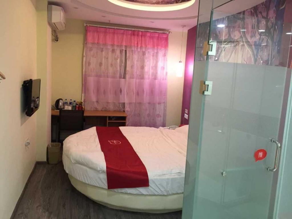 a bedroom with a bed with a red and white blanket at Thank Inn Chain Hotel Jiangsu Yixing Dingshu Town East Jiefang Road in Zhoushu