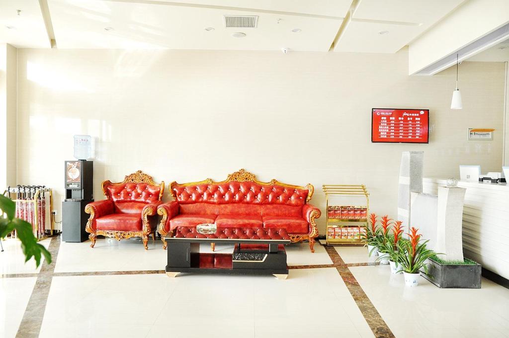 two red leather couches sitting in a room at Thank Inn Chain Hotel Shandong Zibo Zichuan Luzhong International Shopping mall in Zibo