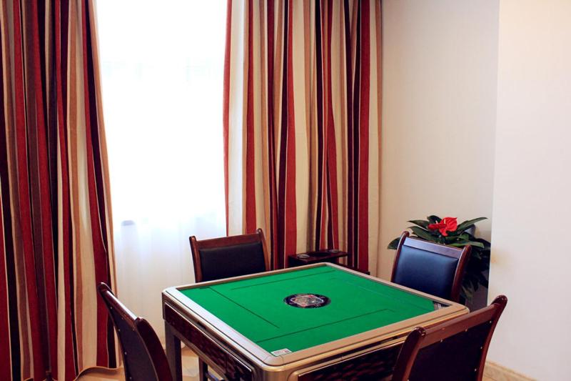 una mesa de ping pong con sillas y una pantalla verde en Thank Inn Plus Hotel Shandong Daminghu en Jinan