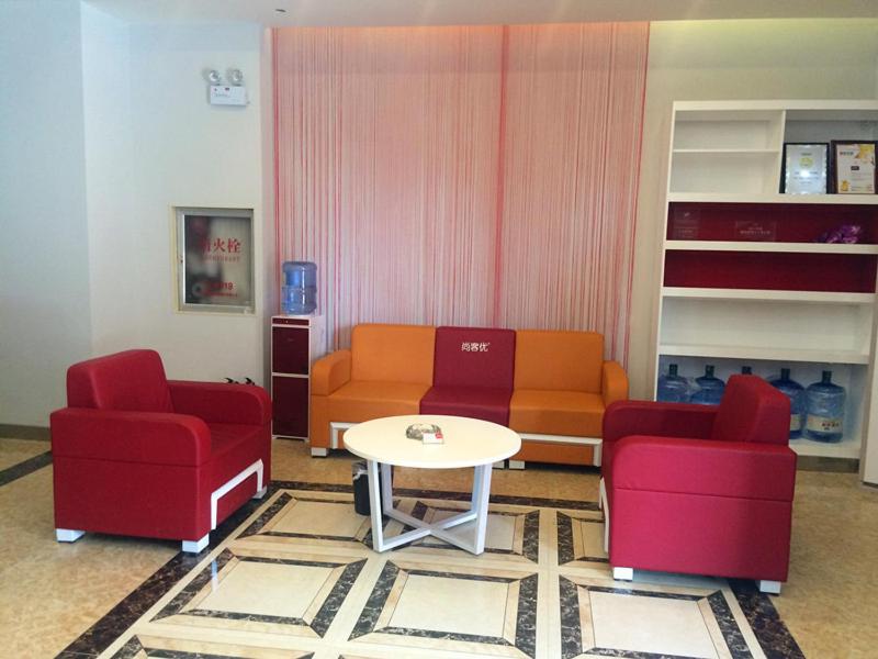 a living room with two red chairs and a table at Thank Inn Chain Hotel Henan Xinyang Shangcheng County Huayuan Road in Shangcheng