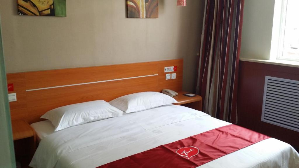 een hotelkamer met een bed met een hartdeken bij Thank Inn Chain Hotel Shanxi Lvliang County Taihe North Road in Houganquan