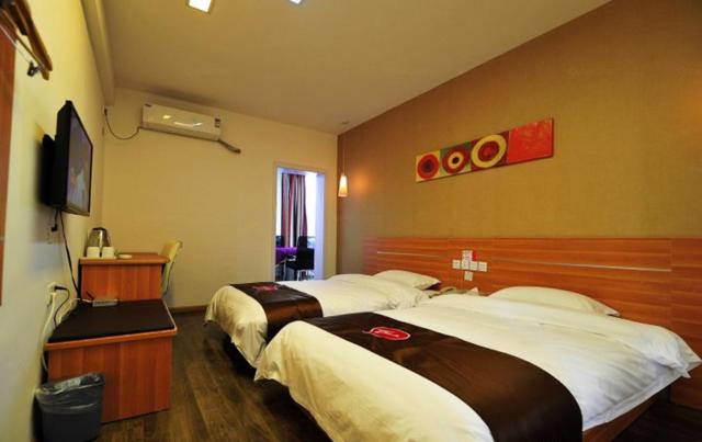 a hotel room with two beds and a television at Thank Inn Chain Hotel Guizhou Anshun Development Area Xihang Road in Anshun