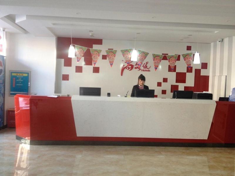 a woman sitting at a counter in an office at Thank Inn Chain Hotel Hebei Langfang the 6th Street in Langfang