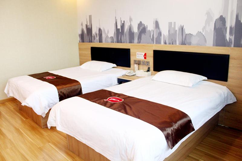 2 bedden in een hotelkamer met witte lakens bij Thank Inn Chain Hotel Hebei Shijiazhuang Xingtang Town North Yongchang Road in Jicun