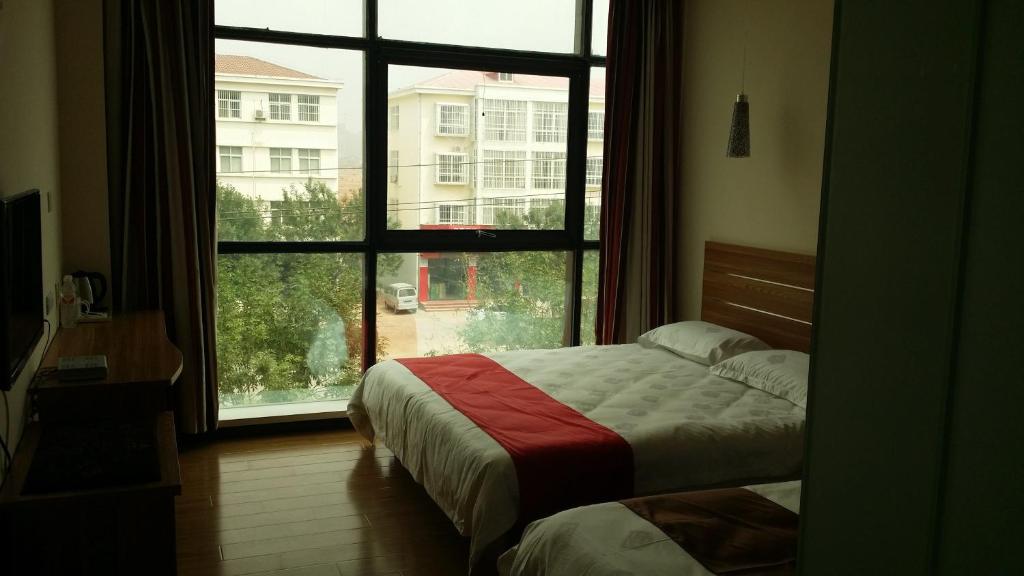 a bedroom with a bed and a large window at Thank Inn Chain Hotel Hebei Cangzhou Qing County Nanhuan Road in Qing