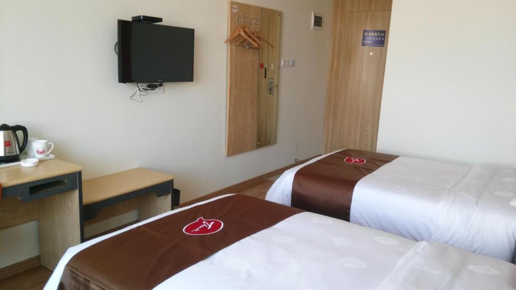 a hotel room with two beds and a flat screen tv at Thank Inn Chain Hotel Jiangxi Fuzhou Linchuan District Laowuhuang Palace Bus Station in Fuzhou