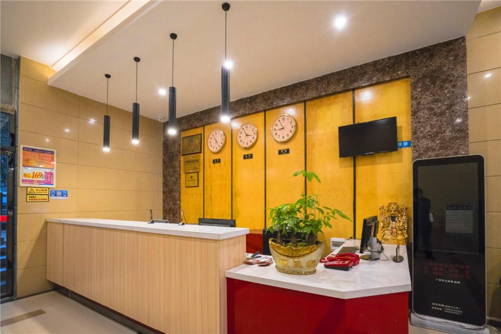 un vestíbulo con un mostrador y relojes en la pared en Thank Inn Chain Hotel Sichuan Guangan Wusheng County Hongwu Avenue, en Wusheng