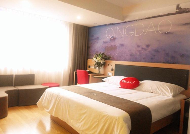 Habitación de hotel con cama grande y sofá en Thank Inn Plus Hotel Shandong Qingdao Development Zone Xiangjiang Road Changjiang Shopping Mall en Yen-t'ai-ch'ien