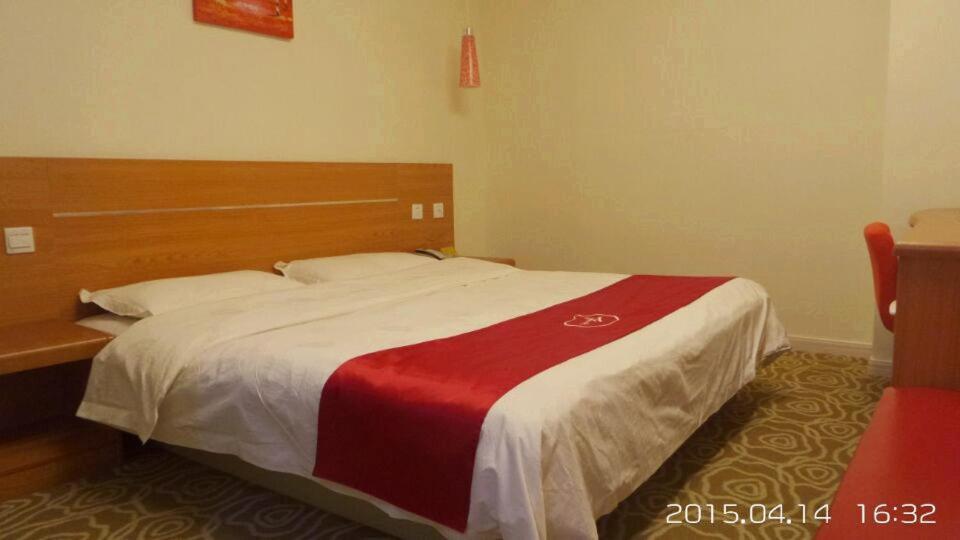a bedroom with a bed with a red and white blanket at Thank Inn Chain Hotel Jiangsu Wuxi New District Taibo Avenue in Wuxi