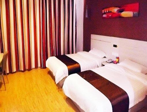 una camera d'albergo con due letti in una stanza di Thank Inn Chain Hotel Shandong Shouguang New Bus Station a Shouguang