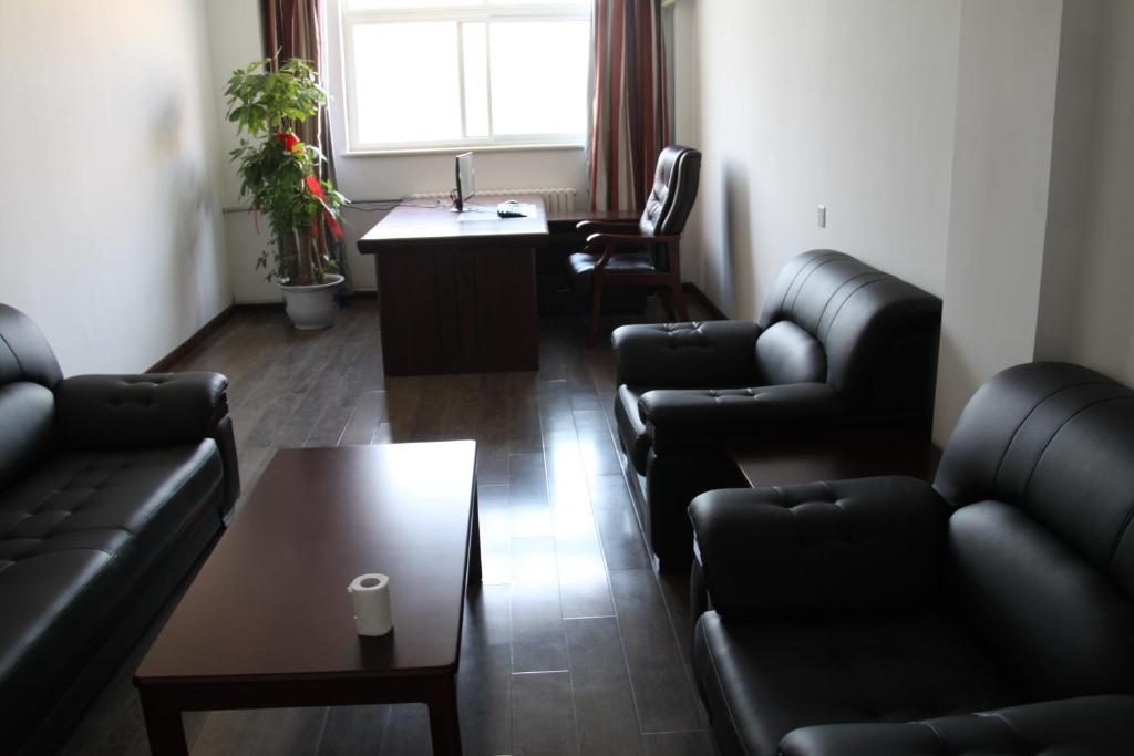 a living room with leather furniture and a table at Thank Inn Chain Hotel Shandong Liaocheng Economic Development Zone Jiuhe Community in Liaocheng