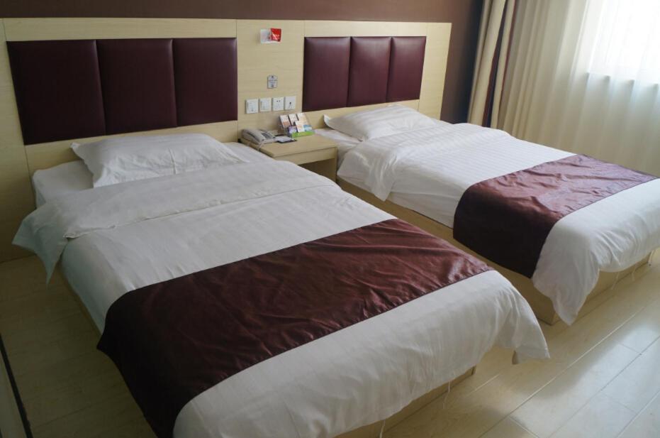 a hotel room with two beds and a window at Thank Inn Chain Hotel Hebei Zhangjiakou Guyuan County Yingbin Avenue in Guyuan