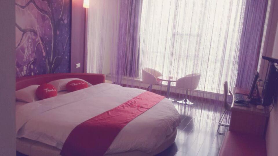 Habitación de hotel con cama, mesa y sillas en Thank Inn Chain Hotel Shanxi Lvliang Lishi Beichuanghe Road, en Luliang