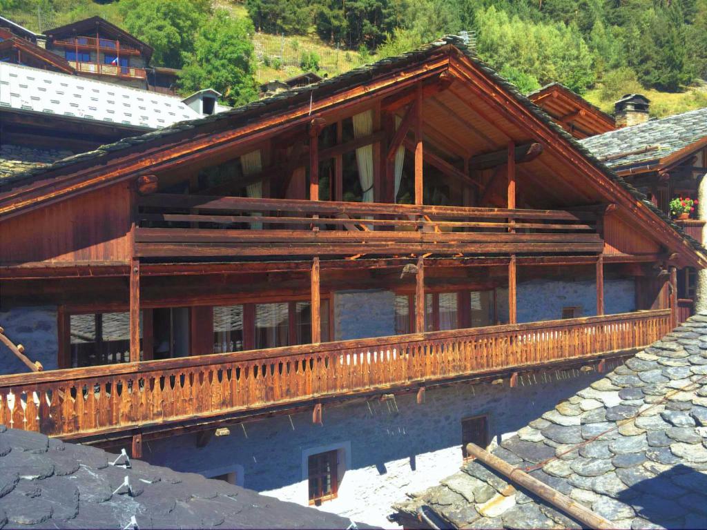 a large wooden house with a reflection in the water at Chalet Geneviève in Sainte-Foy-Tarentaise